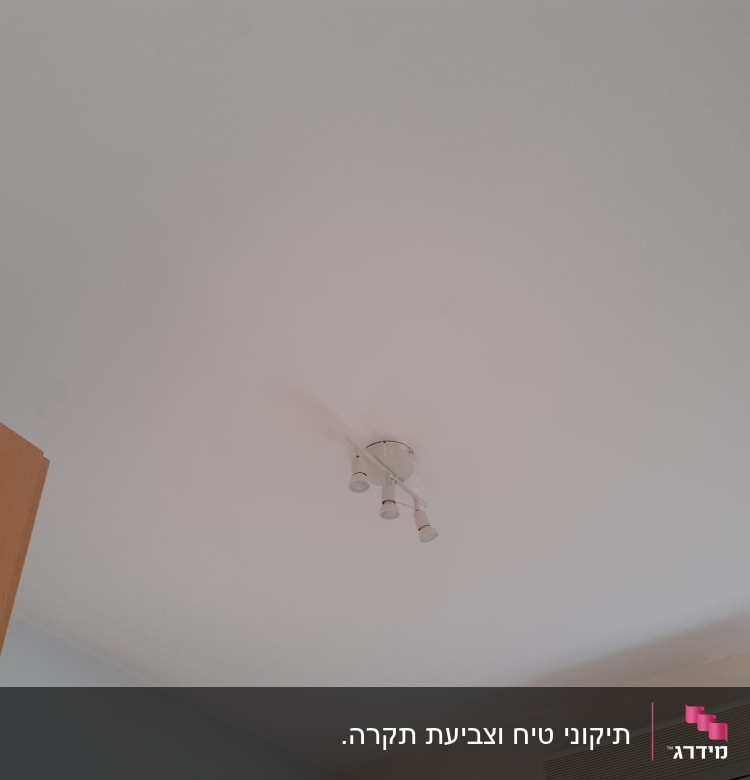 תקרה צבועה בלבן עם מנורה במרכז